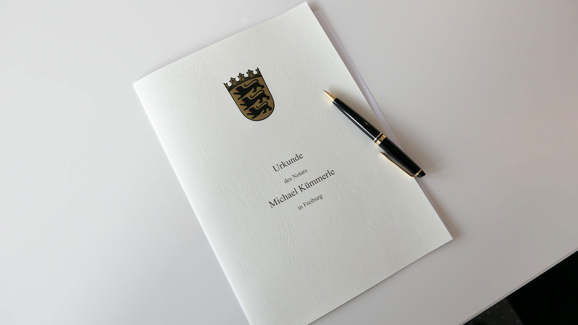 Bild zeigt einen Urkunden-Umschlag mit einem Kugelschreiber